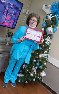 Franklin-Simpson employee of the month Terri Ward standing in front of Christmas tree