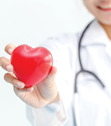 female doctor holding red heart shaped stress ball