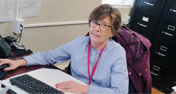 Kathy Johnson Business Office Manager sitting at her desk