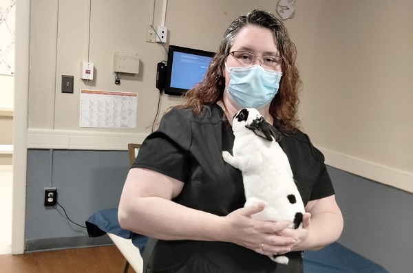 Franklin-Simpson Rehabilitation Employee Jamie Warren holding a fluffy white bunny and posing for photo