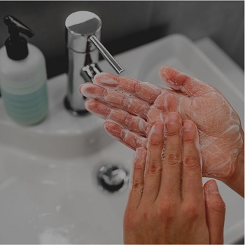 close up of person washing hands in bathroom sink